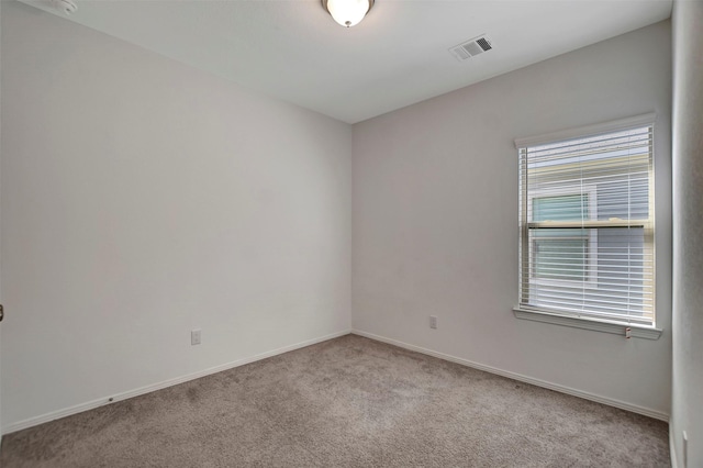 empty room featuring baseboards, visible vents, and carpet flooring