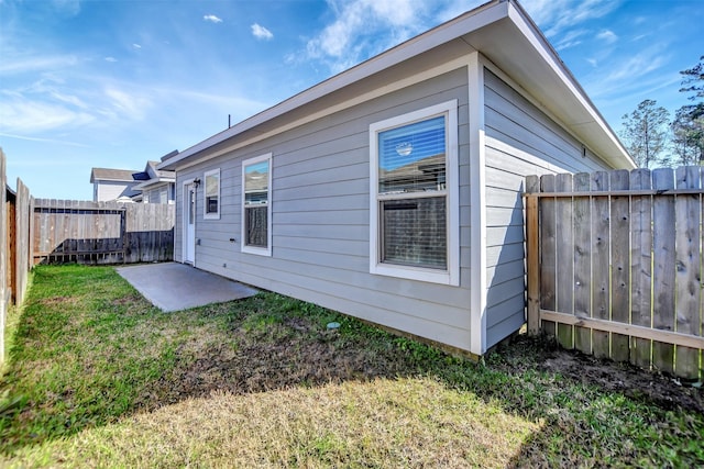 rear view of property featuring a yard and a fenced backyard