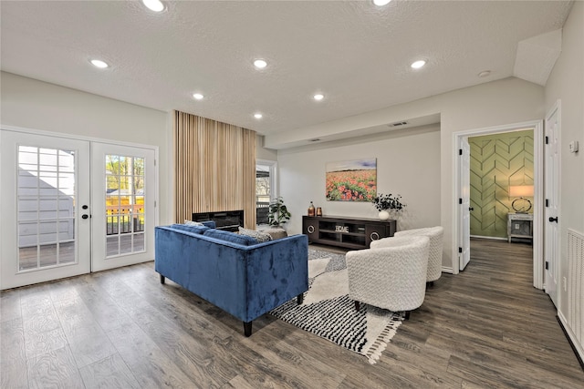 living room with french doors, a fireplace, recessed lighting, a textured ceiling, and wood finished floors