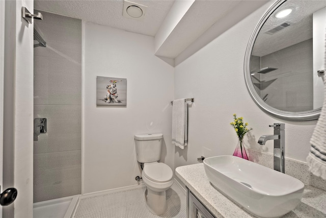 full bath featuring visible vents, toilet, a stall shower, vanity, and a textured ceiling