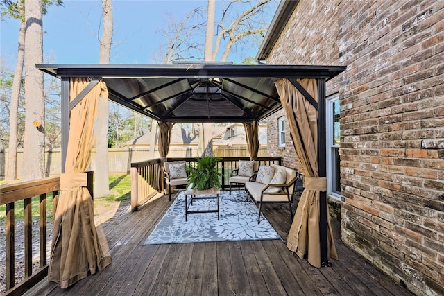 wooden deck featuring a gazebo, outdoor lounge area, and fence