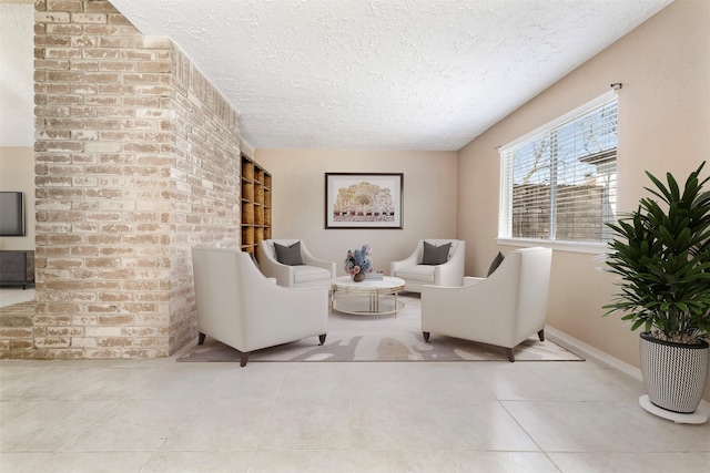 living area featuring a textured ceiling, baseboards, and tile patterned floors