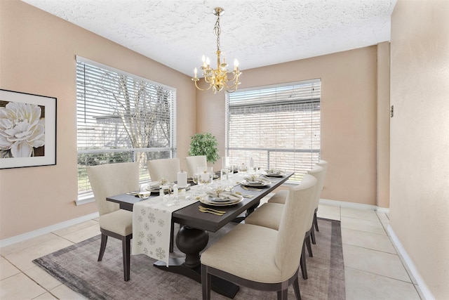 dining room with a chandelier, light tile patterned flooring, a textured ceiling, and baseboards