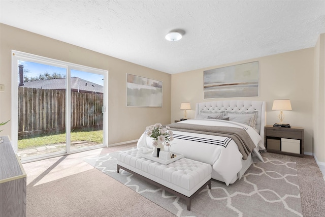 bedroom featuring a textured ceiling, carpet floors, access to outside, and baseboards