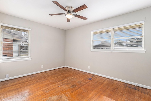 empty room featuring hardwood / wood-style flooring, ceiling fan, and baseboards