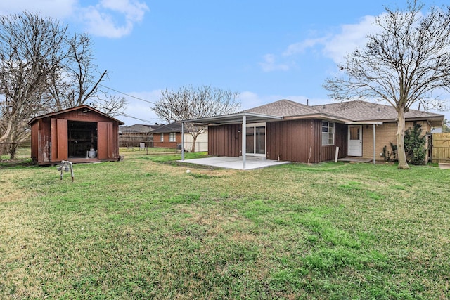 view of yard with an outbuilding, a storage unit, a patio area, and fence