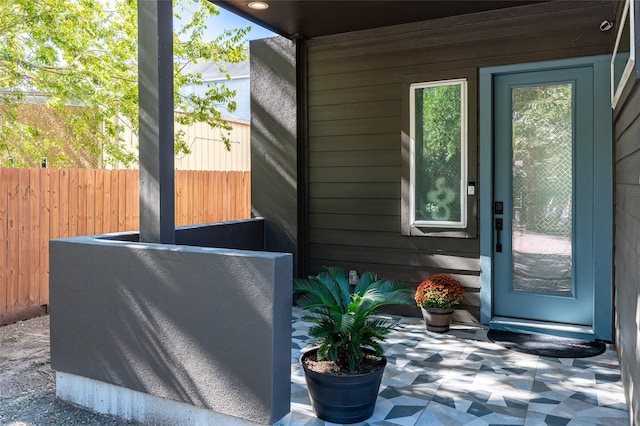 doorway featuring a healthy amount of sunlight, wood walls, and tile patterned floors