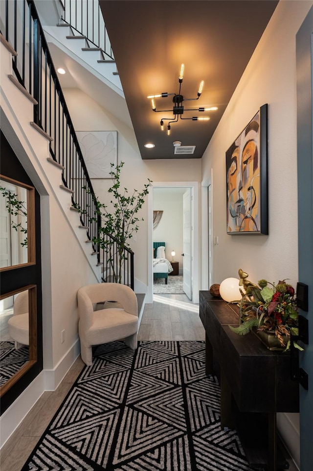 hall with stairs, wood finished floors, and baseboards