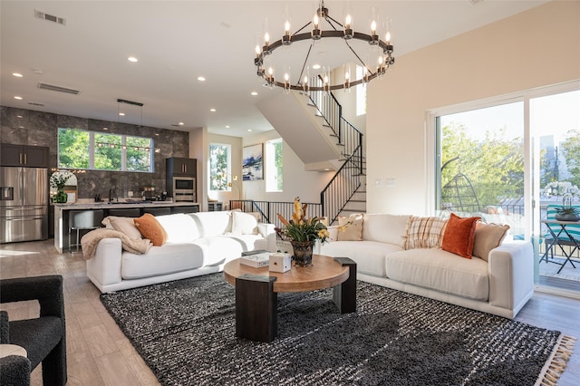 living room with stairway, visible vents, and recessed lighting