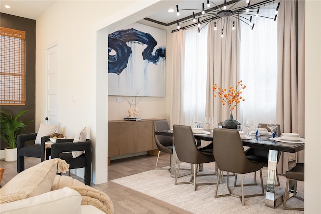 dining space featuring light wood-type flooring, a wealth of natural light, recessed lighting, and an inviting chandelier