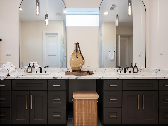 bathroom featuring double vanity, visible vents, and a sink