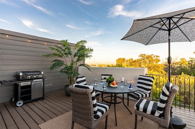 deck with outdoor dining space and a grill