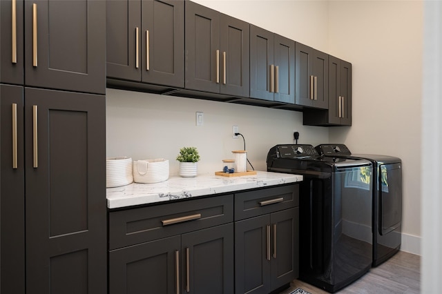 laundry area with cabinet space, baseboards, light wood-style floors, and washer and dryer