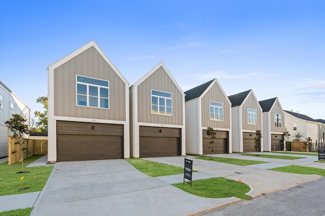 1016 Patton St, Houston, TX 77009 - view of front of home with board and batten siding, concrete driveway, fence, and a garage