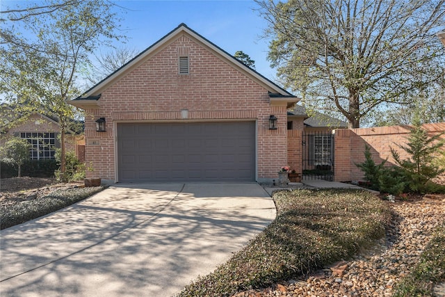 view of front of house with concrete driveway, brick siding, an attached garage, and fence