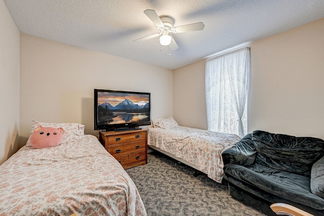 carpeted bedroom featuring a ceiling fan and a textured ceiling