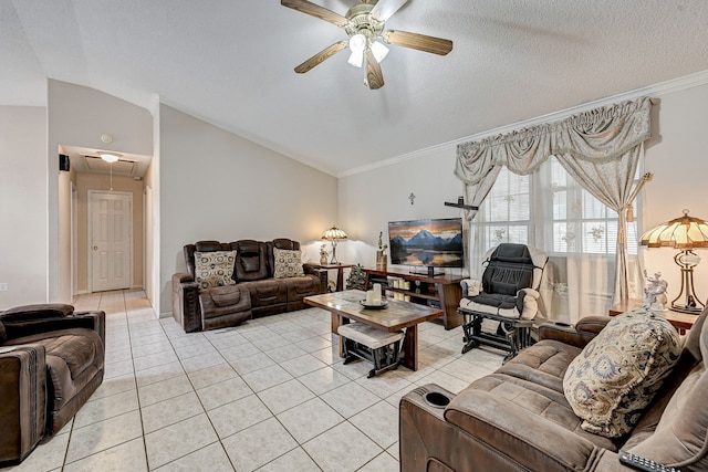 living area featuring light tile patterned flooring, a ceiling fan, vaulted ceiling, ornamental molding, and attic access