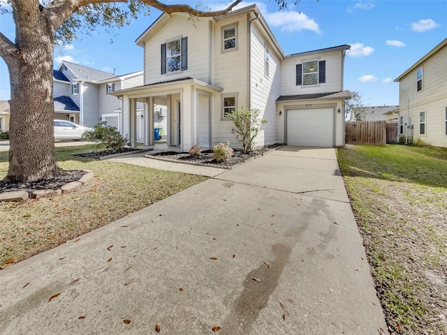 traditional home with driveway, a garage, fence, and a front yard