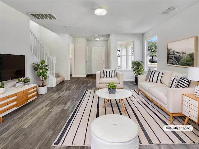 living room featuring visible vents, stairway, and wood finished floors