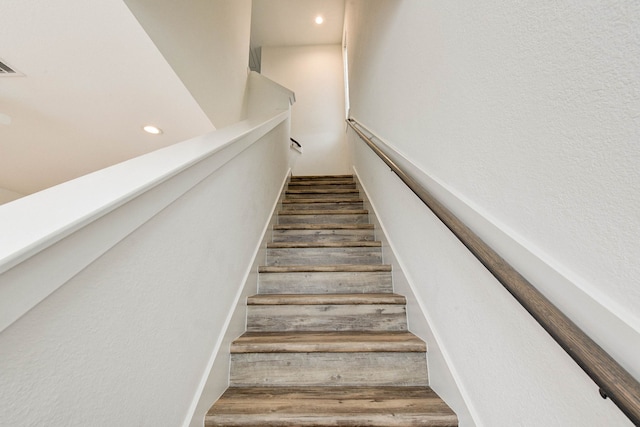 staircase featuring wood finished floors and recessed lighting