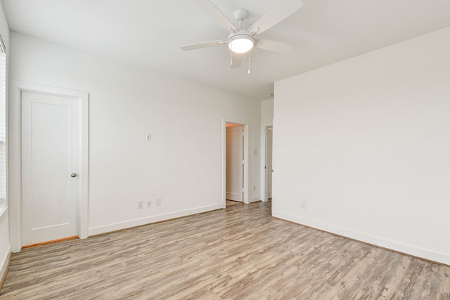 empty room featuring light wood-type flooring, ceiling fan, and baseboards