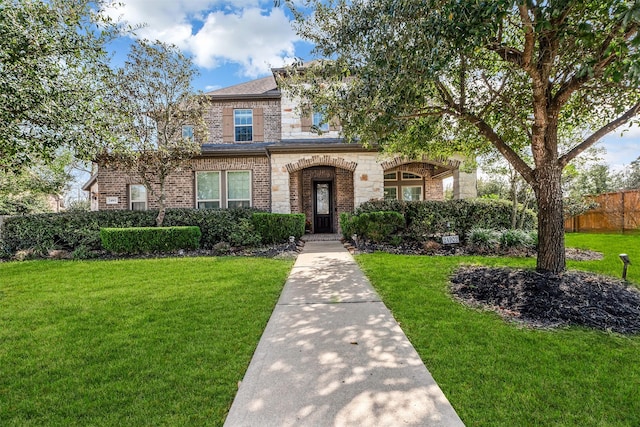 view of front of house featuring a front yard, fence, and brick siding