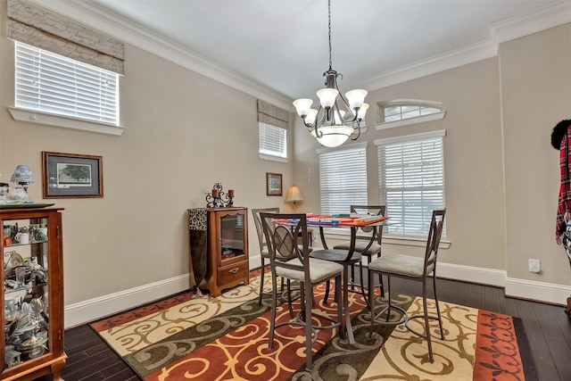 dining space with a chandelier, ornamental molding, baseboards, and hardwood / wood-style flooring