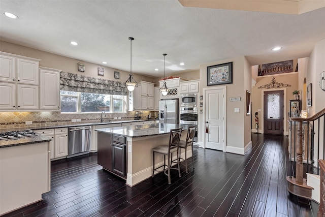 kitchen featuring decorative backsplash, dark stone countertops, white cabinets, and appliances with stainless steel finishes