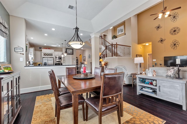 dining area featuring visible vents, dark wood-type flooring, recessed lighting, stairway, and ornate columns