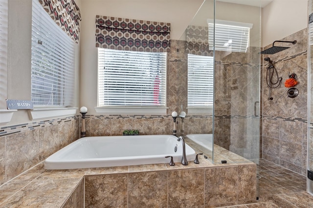 full bath with a garden tub and a tile shower