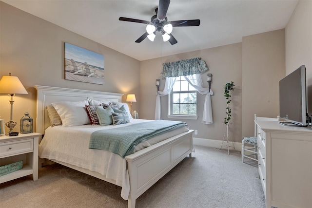 bedroom with light colored carpet, baseboards, and ceiling fan