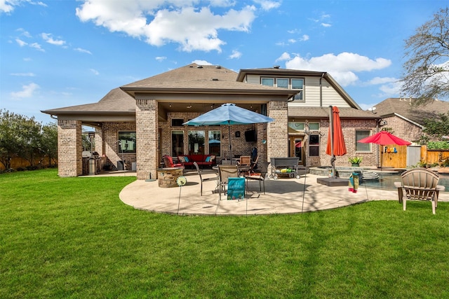 rear view of property featuring a yard, a patio, brick siding, and roof with shingles