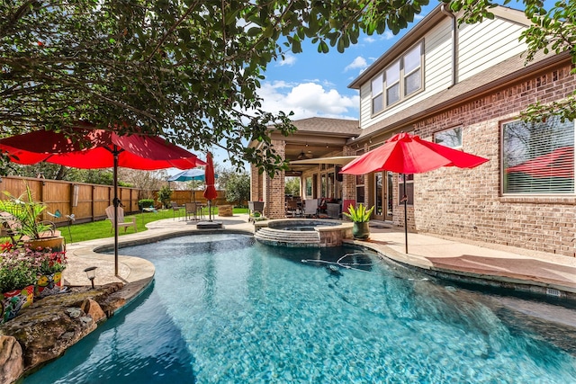 view of pool with a pool with connected hot tub, a patio area, and a fenced backyard