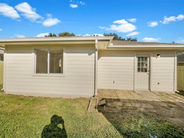 back of property featuring a patio and a lawn