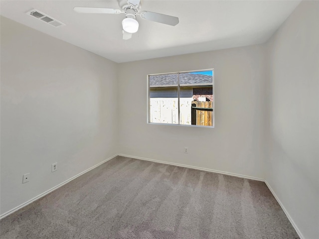carpeted empty room with ceiling fan, visible vents, and baseboards