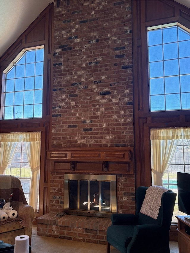 carpeted living area with high vaulted ceiling and a fireplace