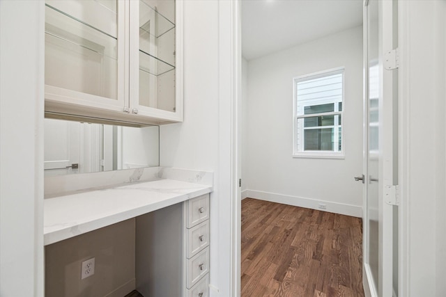 unfurnished office featuring dark wood-type flooring and baseboards