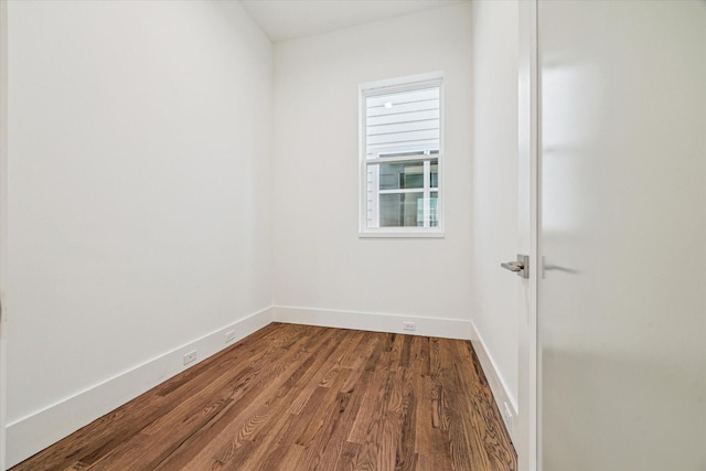 unfurnished room with baseboards and dark wood-style flooring