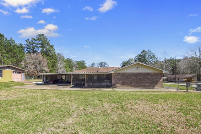 back of house featuring a yard, fence, and brick siding