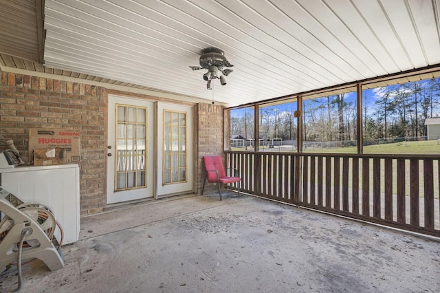 unfurnished sunroom featuring a ceiling fan