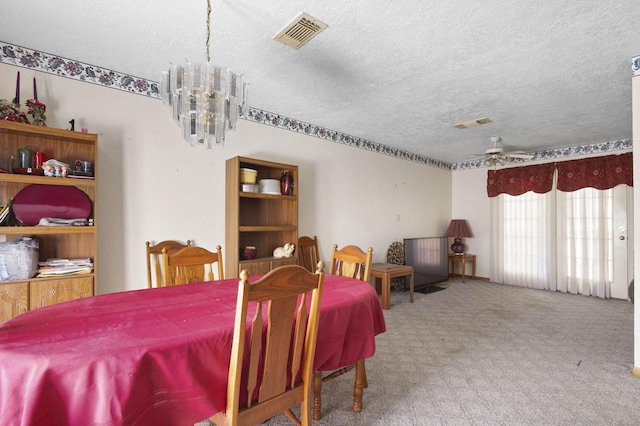 dining area with carpet floors, visible vents, a textured ceiling, and ceiling fan with notable chandelier