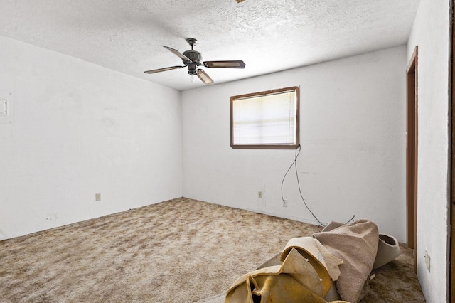 empty room featuring a textured ceiling, carpet floors, and a ceiling fan