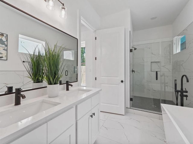 full bath featuring marble finish floor, a marble finish shower, a wealth of natural light, and a sink