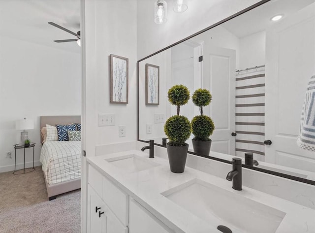 ensuite bathroom featuring ceiling fan, double vanity, a sink, and ensuite bathroom