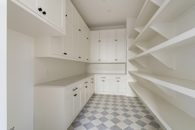 interior space with white cabinetry, open shelves, light floors, and light countertops