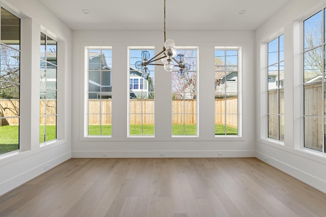 unfurnished sunroom featuring a notable chandelier and plenty of natural light