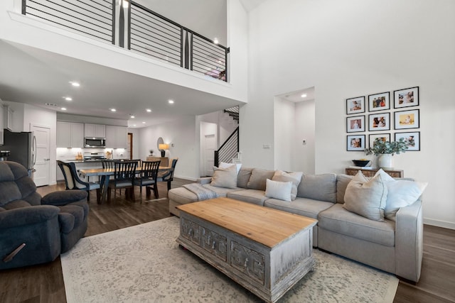 living area featuring stairs, recessed lighting, wood finished floors, and baseboards