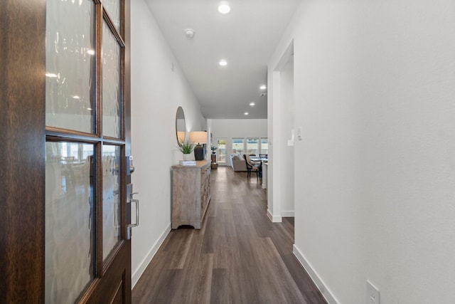 corridor with arched walkways, dark wood-style flooring, recessed lighting, and baseboards