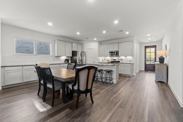 dining room with visible vents, baseboards, wood finished floors, and recessed lighting