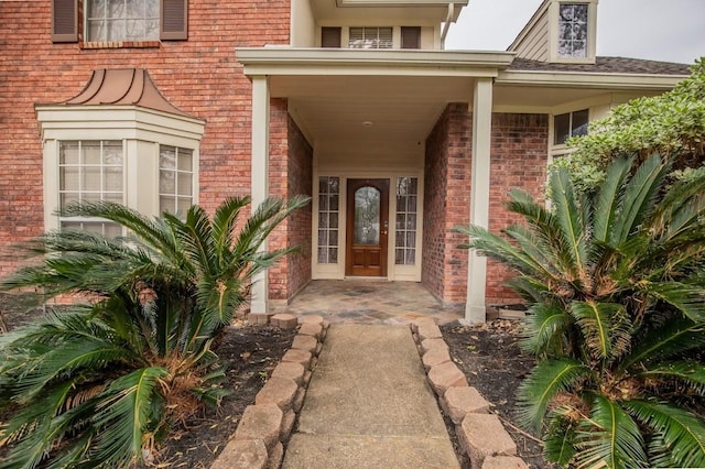 entrance to property featuring brick siding